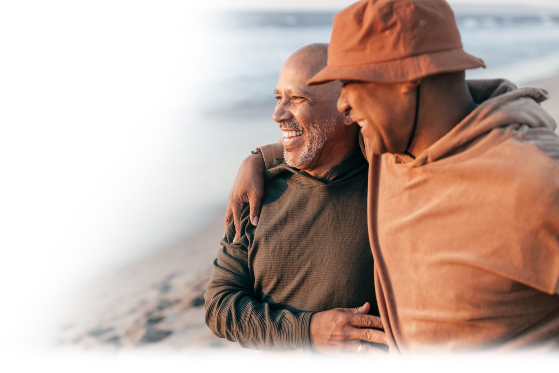 Two men on the beach smiling