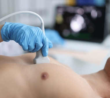 Doctor performs chest ultrasound on man in hospital closeup