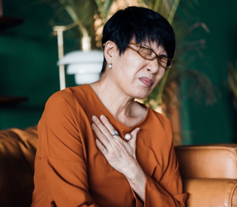 senior asian woman having chest pains