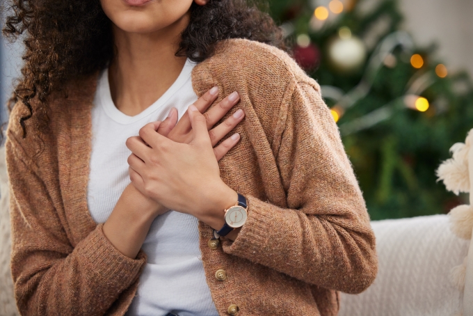 young woman holding her chest in pain